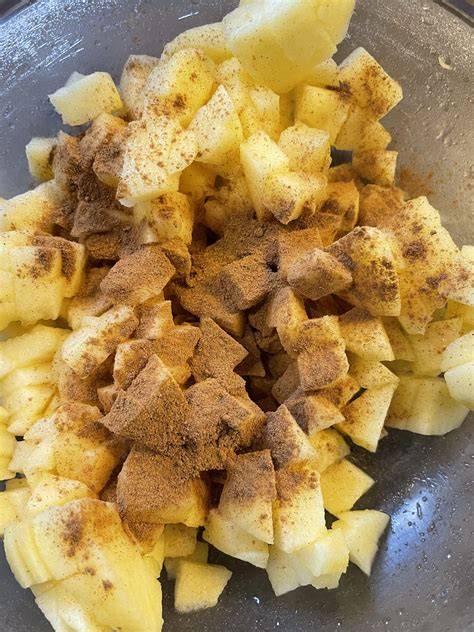 Apfelscheiben vermischt mit Zimt und Zitronensaft