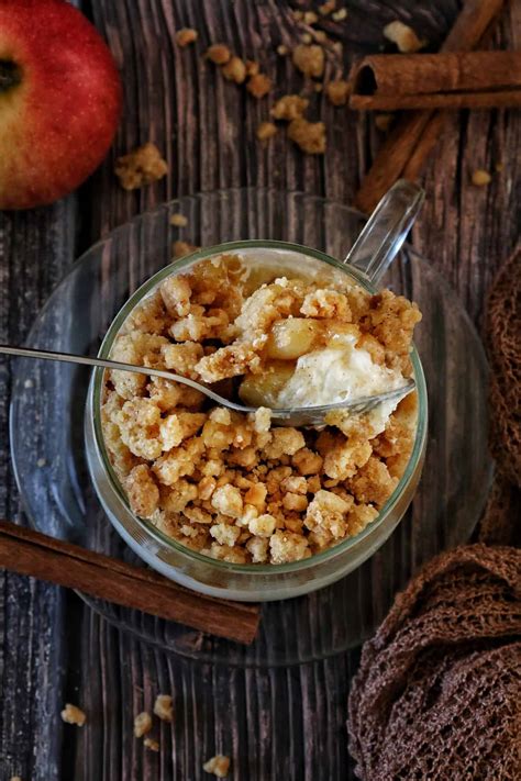 Appetitliches Dessertglas mit Apfel Crumble und Sahnehaube, herbstlich dekoriert