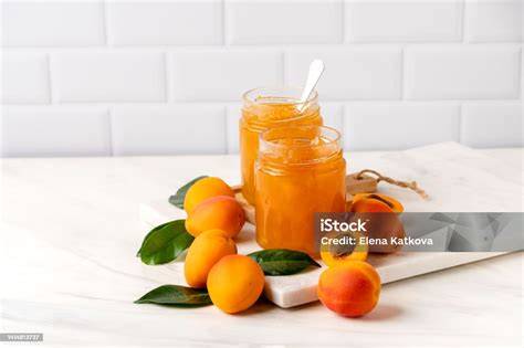 Aprikosenmarmelade im Glas und frische Aprikosen