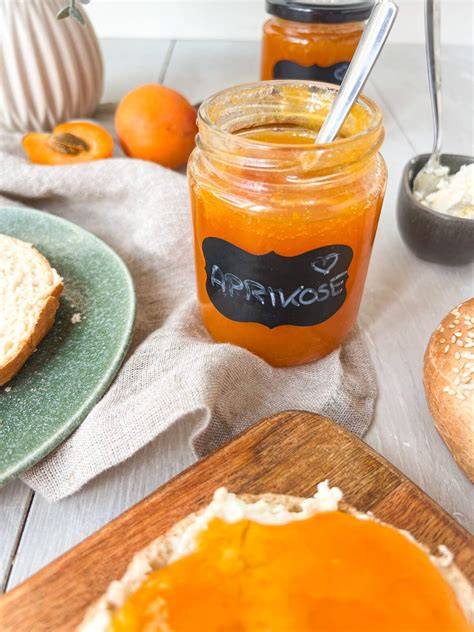 Aprikosenmarmelade im Topf und eingestrichener Kuchen