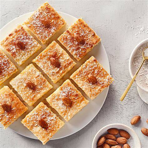 Arabische Torte Hariseh auf Teller garniert mit Mandeln und Orangenblüten