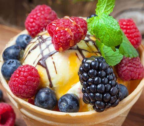 Arrangement verschiedener Dessertschalen mit Früchten und Eis