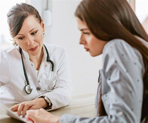 Arzt und Patientin im Gespräch zur Abklärung von Symptomen