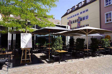 Außenbereich mit Tischen und Sonnenschirmen