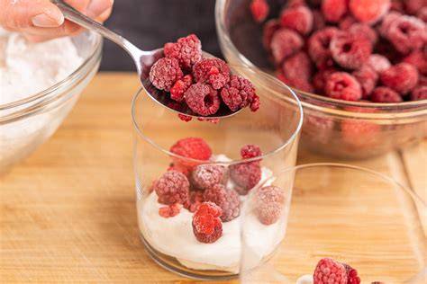 Aufbau der Schichten: Himbeeren, Baiser, Sahne-Joghurt-Creme