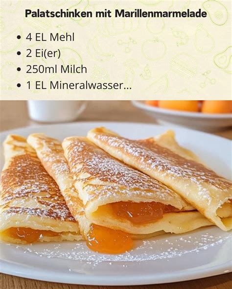 Aufgerollte Palatschinken mit Marillenmarmelade auf Teller, bestäubt mit Staubzucker