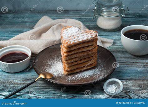 Aufgeschäumter Kokos-Latte neben einem Stapel Waffeln