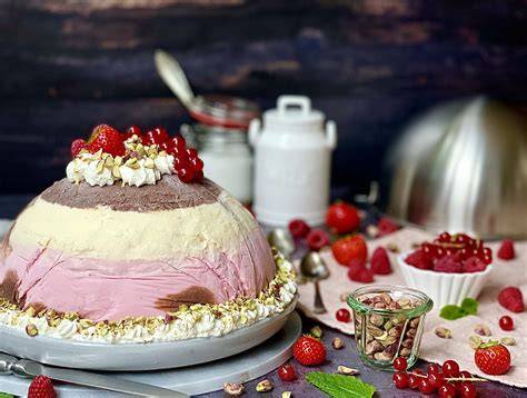 Aufgeschnittene Eisbombe mit Schichten aus Sahne, Keksen und Beeren