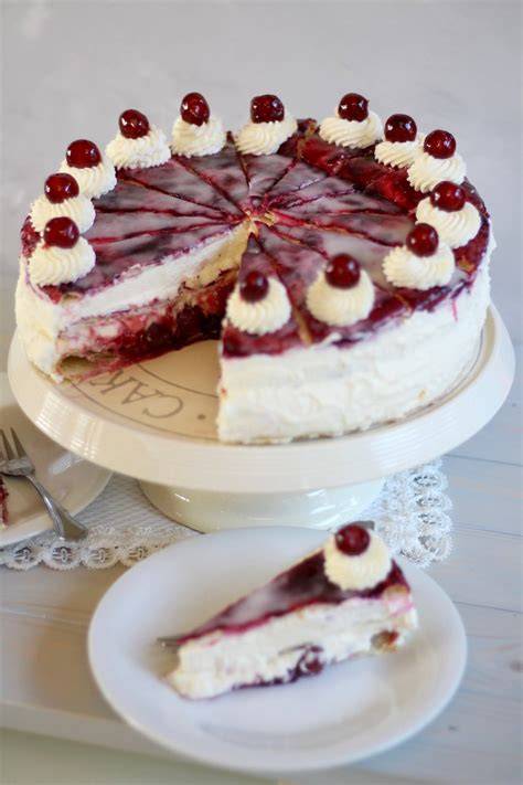 Aufgeschnittene Käsesahnetorte mit Kirschen und Puderzucker