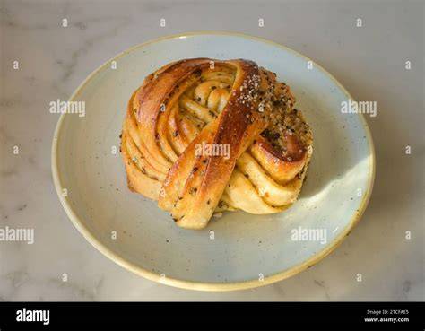 Aufgeschnittene Zimtschnecke und Kardamom Bun auf Tellern
