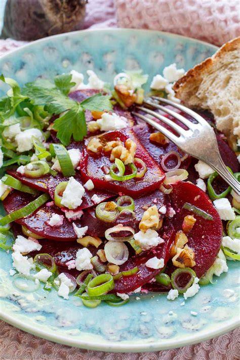 Aufgeschnittene rote Bete Scheiben und Feta auf Schneidebrett