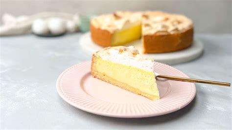 Aufgeschnittener Käsekuchen mit weißer Baiserhaube und goldenen Tröpfchen