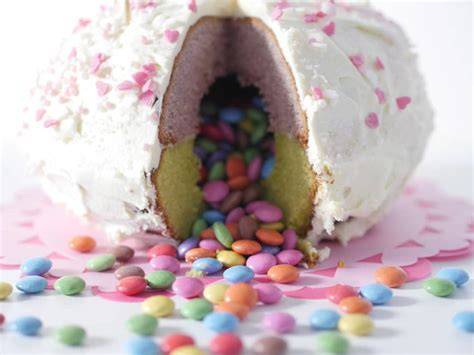 Aufgeschnittener Pinata-Kuchen mit herausfallenden Smarties
