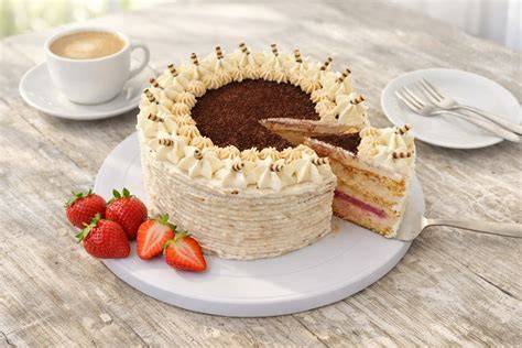 Aufgeschnittener Stroopwafel-Kuchen auf einer Tortenplatte mit Kaffee