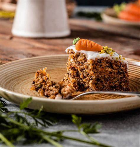 Aufgeschnittener veganer Carrot Cake mit Frischcremetopping und Haselnuss-Krokant