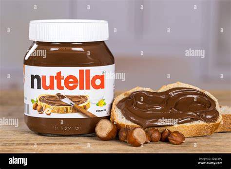 Aufgeschnittenes Glas Nuss-Nougat-Creme auf Brot