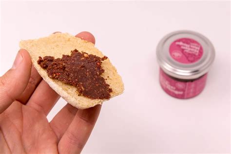 Aufgeschnittenes Glas mit hausgemachtem Nuss-Schoko-Aufstrich auf Brot