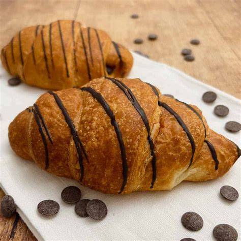 Aufgeschnittenes Schokoladencroissant mit luftigen Schichten und dunkler Schokolade