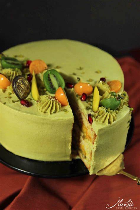 Aufgestrichene Sahnecreme auf Torte, dekoriert mit halbierten Physalis und gehackten Pistazien