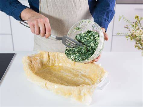 Auflaufform mit geschmolzener Butter und Teigblättern