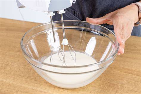 Aufschlagen von Sahne im Schneebesen: frisch geschlagene Schlagsahne