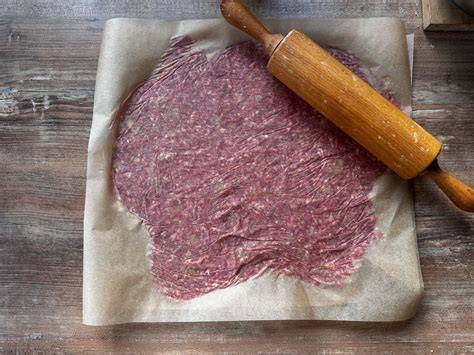 Ausgerollter Cracker-Teig zwischen Backpapier
