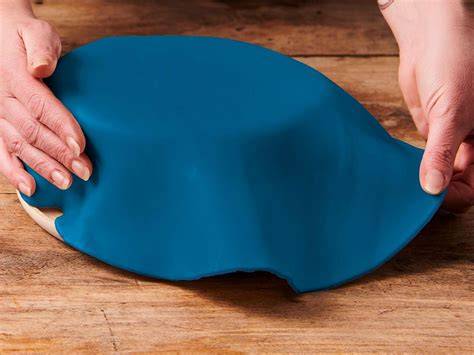 Ausgerollter Fondant auf Silikonmatte mit Rollstab
