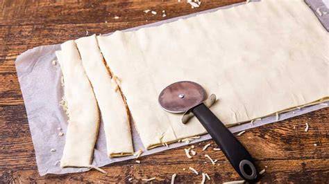 Ausgerollter Plunderteig mit Markierungen und Pizzaschneider
