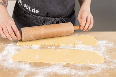 Ausgerolltes Marzipan auf Puderzucker-Arbeitsfläche