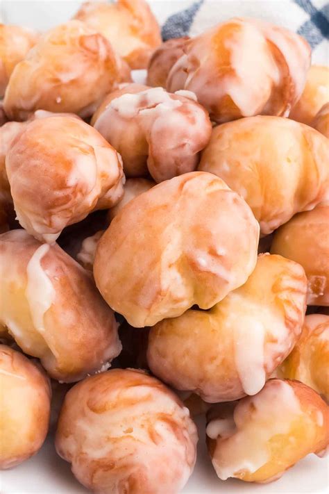 Ausgestochene rohe Donuts und Donut Holes auf Backpapier
