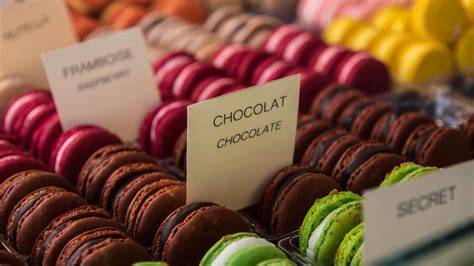 Auslage mit Schokoladenskulpturen, Pralinen, Macarons und saisonalen Figuren