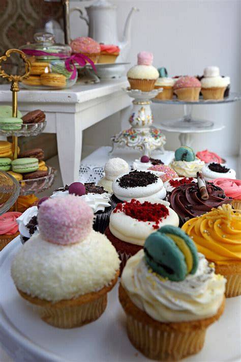 Auslage mit bunten Cupcakes und Torten im Schaufenster