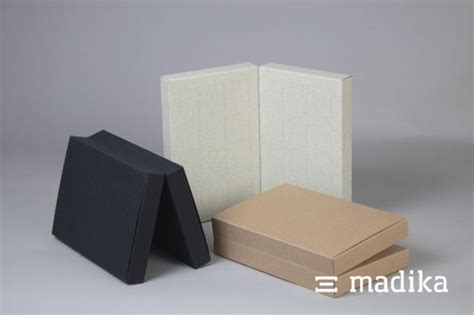 Auswahl an Kartonsorten: Chromokarton weiß, Naturkarton braun, Naturkarton schwarz, Graspapier