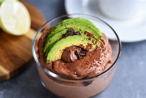 Avocado und Kakaopulver auf Holzbrett