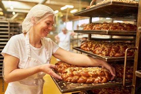 Bäckerin bei der Arbeit mit Drehteller, Tortenring und Spachtel