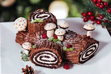 Bûche de Noël mit weißer Fondantglasur und Mohn-Dekor in Baumstammform