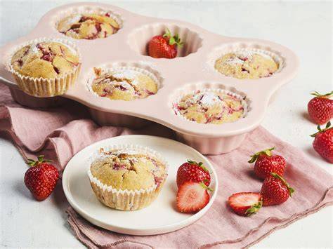 Backen mit Erdbeeren: Muffins, Zutaten und Streuselteig auf einem Holztisch