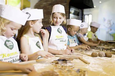 Backen mit kindgerechten Utensilien, Kinder mit Schürzen und Teig