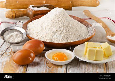 Backzutaten für Blechkuchen: Mehl, Eier, Butter, Zucker, Obst, Nüsse und Deko