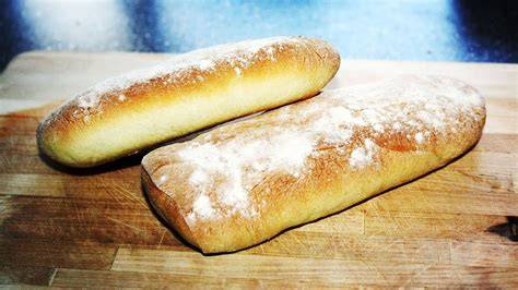 Baguette und Ciabatta auf einem Holzbrett