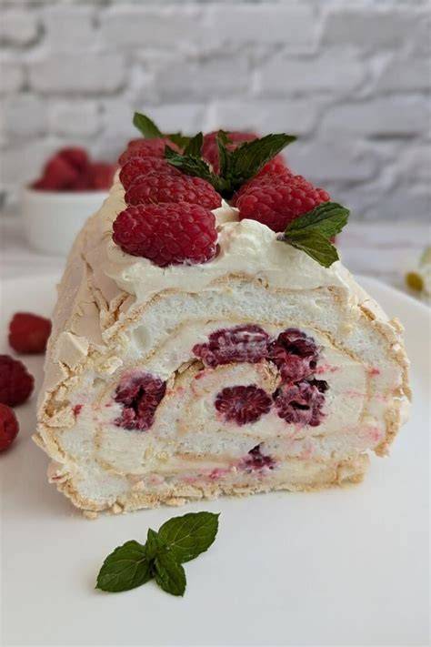 Baiserrolle (Pavlova Roll) mit Himbeeren, Pistazien und Sahne aufgeschnitten
