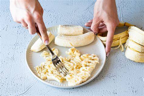 Bananen zerdrücken mit Gabel und Schüssel