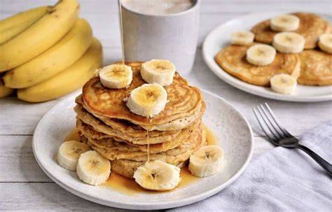 Bananen-Pancakes auf einem Teller mit Ahornsirup