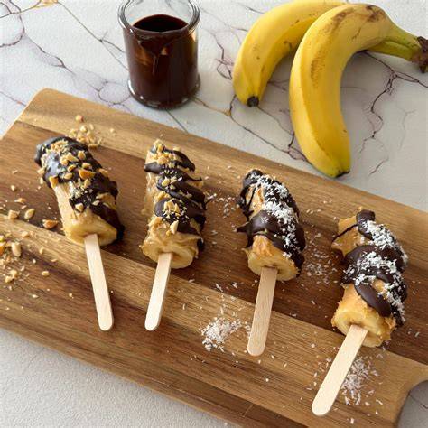 Bananeneis am Stiel, umhüllt mit Schokolade und Haselnüssen