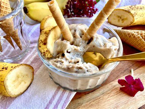 Bananeneis mit Joghurt, angerichtet in einem Glas und belegt mit Haferkeksen und Honig