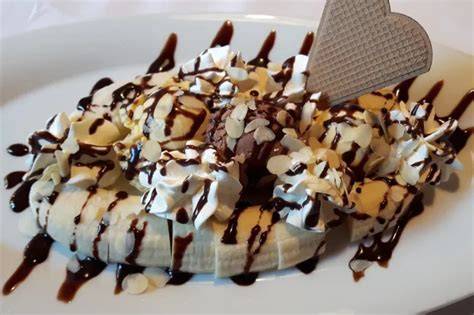 Bananenhälften mit geschmolzenen Schokoriegelstücken und Vanilleeis