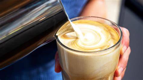 Barista Milch mit Kaffee und Schaum