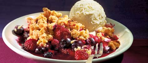 Beeren-Crumble direkt vom Grill, serviert mit Joghurteis auf einem Teller