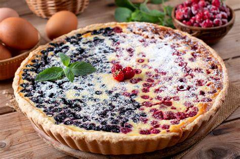 Beeren-Tarte mit Streuseln: Zutatenübersicht und fertige Tarte auf rustikalem Brett