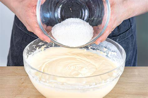 Belag anrühren: Sanella-Zucker-Ei-Masse mit Kokos und Apfelraspeln